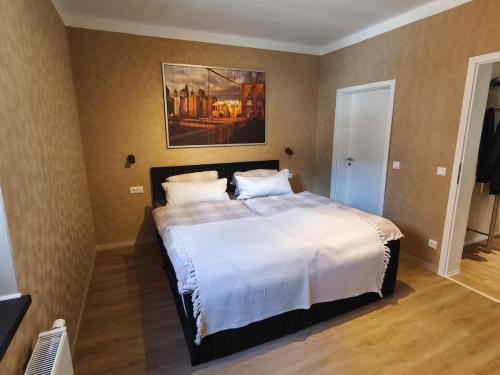 a bedroom with a bed with a painting on the wall at Hehlentor Fachwerkwohnung in Celle