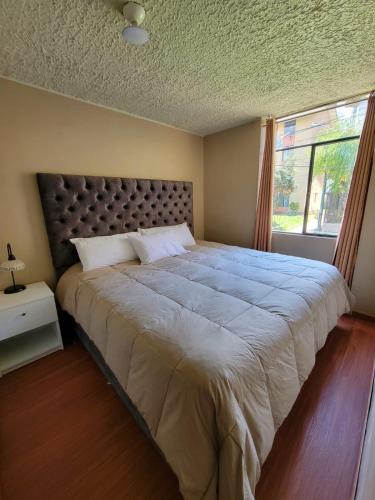 a large bed in a bedroom with a large window at Llama House Cusco in Cusco