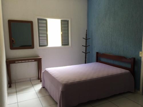 a bedroom with a bed and a mirror and a window at Casa Praia Boracéia Bertioga in Boracéia