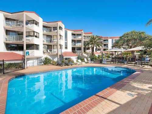 a large blue swimming pool in front of a building at Casablanca Beachfront Apartments in Caloundra