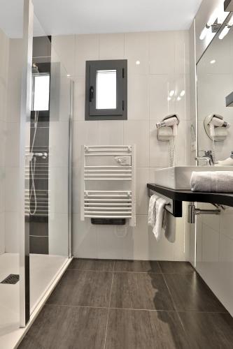 a bathroom with a sink and a shower at Hotel Le Mas de Castel - Piscine chauffee in Sarlat-la-Canéda