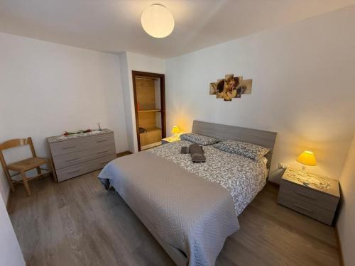 a bedroom with a bed and a dresser and a chair at La Rotonda apartments by Gardadomusmea in Tremosine Sul Garda