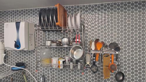 a kitchen with a shelf with utensils on it at June Villa Feel at Home at yelagiri hills in Yelagiri