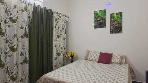 a small bedroom with a bed and a curtain at June Villa Feel at Home at yelagiri hills in Yelagiri