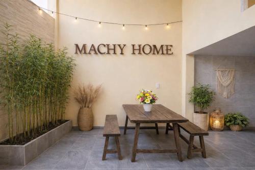 a patio with a wooden table and a sign that reads magic home at Machy Home in Phú Quốc
