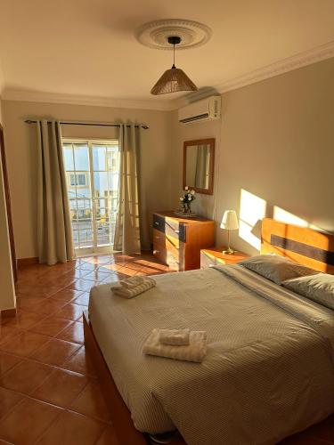 a bedroom with a large bed with two towels on it at Casa Miramar in Tavira