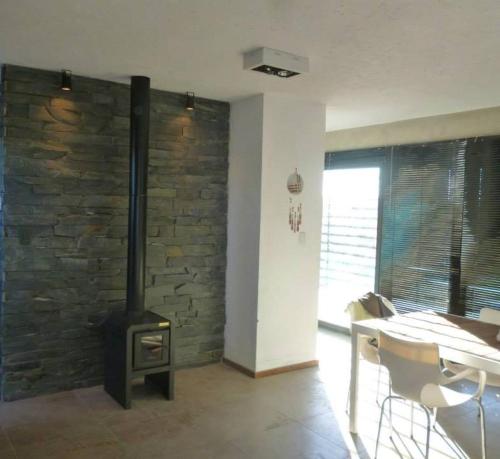 sala de estar con chimenea, mesa y fogones en Casa en las sierras, en Villa Parque Síquiman