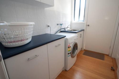 a kitchen with a washing machine and a sink at Cambroe in Lakes Entrance