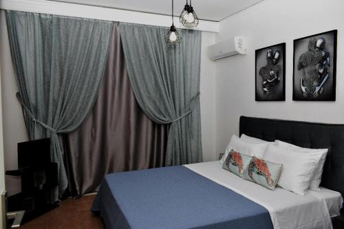 a bedroom with a bed and a window with curtains at Art House by Helen in Soroni Rhodes in Rhodes Town