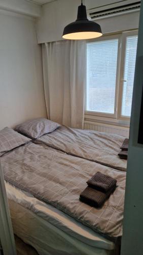 a bedroom with a bed with two towels on it at Economy stay - Self Check-in in Vaasa