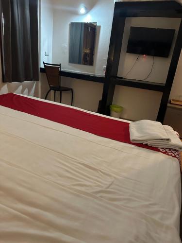 a large white bed with a red stripe on it at Sk Phuket Old Town in Phuket