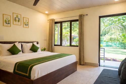 a bedroom with a bed and a large window at Ekantam Riverside Resort in Bijni