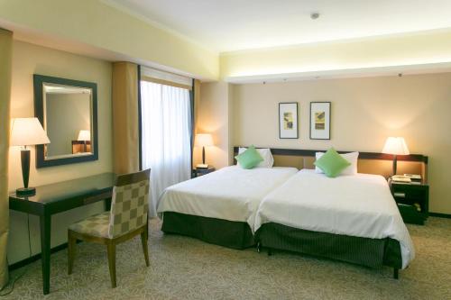 a hotel room with a large bed and a desk at Kanazawa New Grand Hotel Prestige in Kanazawa