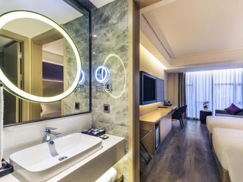 a bathroom with a sink and a mirror at Mercure Chengdu Downtown Hotel in Chengdu
