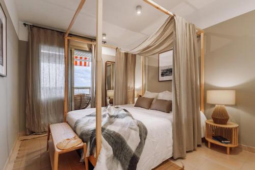 a bedroom with a canopy bed with a window at Impressive beachfront home in Calafell