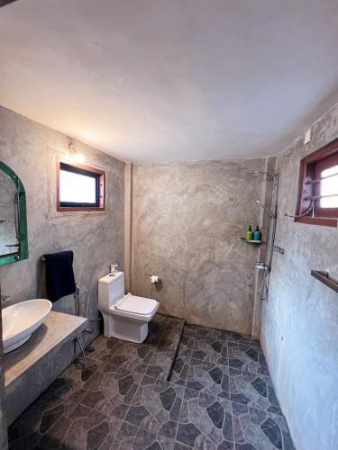 a bathroom with a toilet and a sink at Mariposa Hiriketiya in Dickwella