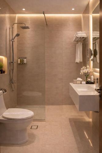 a bathroom with a shower and a toilet and a sink at Carawan Al Khaleej Hotel Olaya in Riyadh