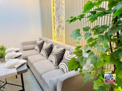 a living room with a couch with pillows on it at URBAN CHIC 1Bedroom Condo Unit at MesaVirre with PlayStation 5, Pool view, and Sunset view in Bacolod