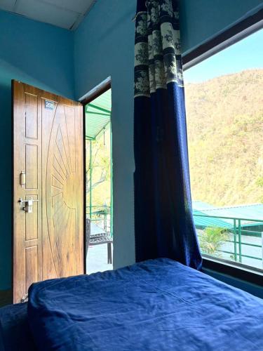a bedroom with a blue bed and a large window at Maasa Retreat & Resort in Shivpuri