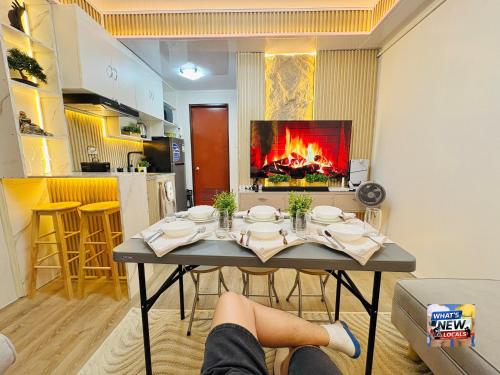 a living room with a table with a fireplace at URBAN CHIC 1Bedroom Condo Unit at MesaVirre with PlayStation 5, Pool view, and Sunset view in Bacolod