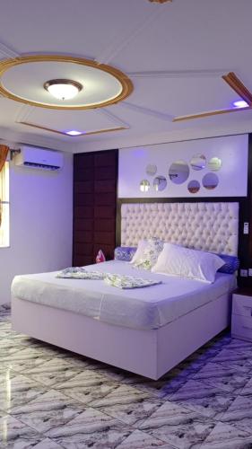 a bedroom with a large white bed in a room at MB California Guest House in Bonabéri