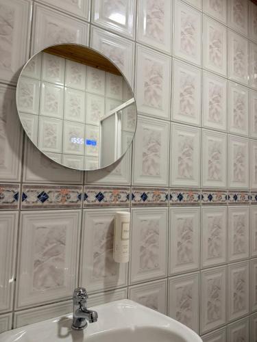 a bathroom with a sink and a mirror on a wall at Casa de São Luís - Turismo Rural in Torre de Moncorvo