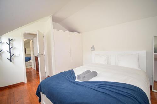 a bedroom with a large bed with a blue blanket at Seaside Family Townhouse - 100m from the sea! in Cascais