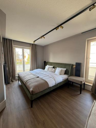 a bedroom with a large bed and a chair at CASAMA am See in Langenargen