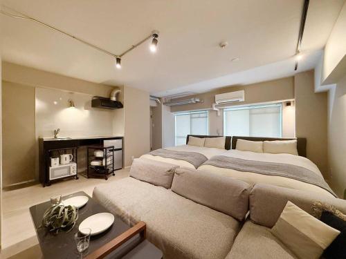 a large bedroom with a large bed and a couch at Origaminn 301 by b hotel - 5 mins Peace Park in Hiroshima