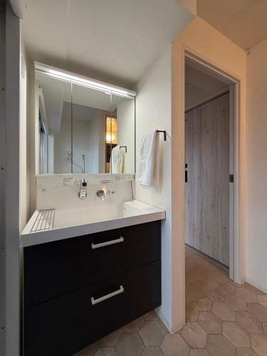 a bathroom with a sink and a large mirror at Origaminn 301 by b hotel - 5 mins Peace Park in Hiroshima