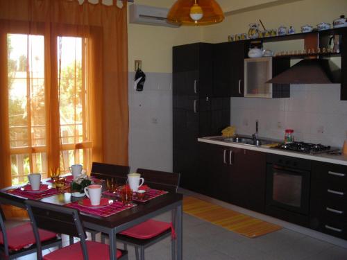 cocina con mesa y sillas y cocina con fregadero en B&B CasAnsaldo, en Giarre