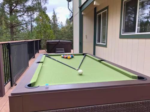 a pool table sitting on a balcony with a house at Large Deck & Spa & Games & Vaulted Ceiling Cabin in Groveland
