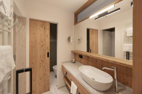 a bathroom with a sink and a mirror at Hotel Ladinia in La Villa