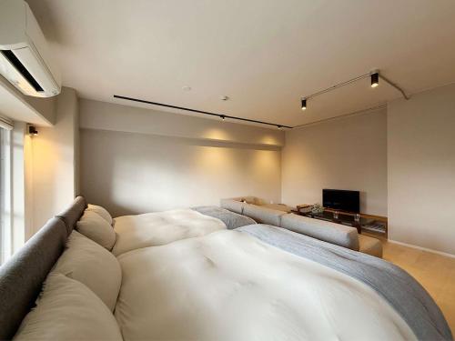 a living room with a couch and a television at Origaminn 401 by b hotel - 5 mins Peace Park in Hiroshima