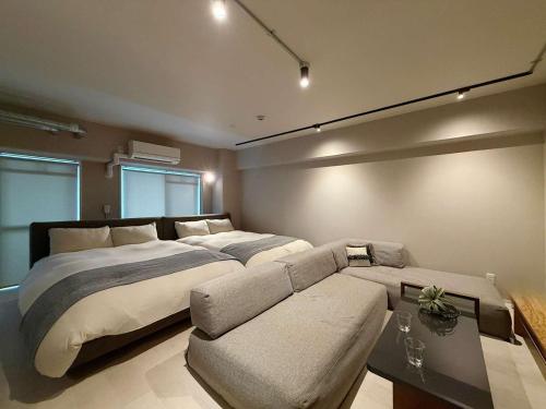 a large bedroom with a large bed and a couch at Origaminn 401 by b hotel - 5 mins Peace Park in Hiroshima