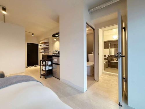 a bedroom with a bed and a bathroom at Origaminn 401 by b hotel - 5 mins Peace Park in Hiroshima