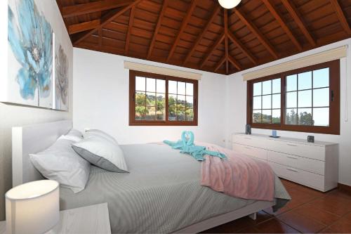 a bedroom with a bed with a blue stuffed animal on it at Casa La Castellana in Tijarafe