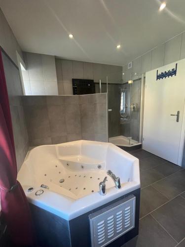 a large bathroom with a tub and a shower at Charming Apartment with Jacuzzi Bathtub in La Chaux-de-Fonds