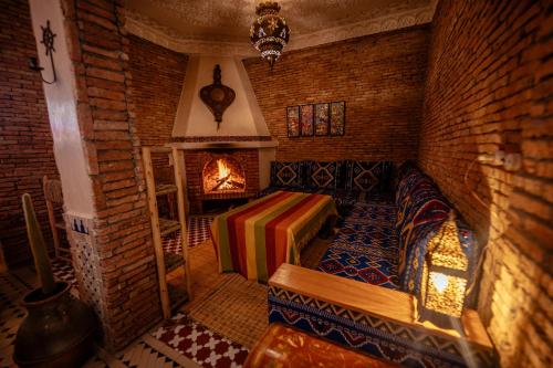 a room with a fireplace and a couch in a room at Riad Bleu Azahraa in Safi