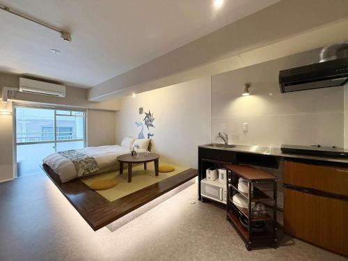 a bedroom with a bed and a table and a sink at Origaminn 303 by b hotel - 5 mins PeacePark in Hiroshima