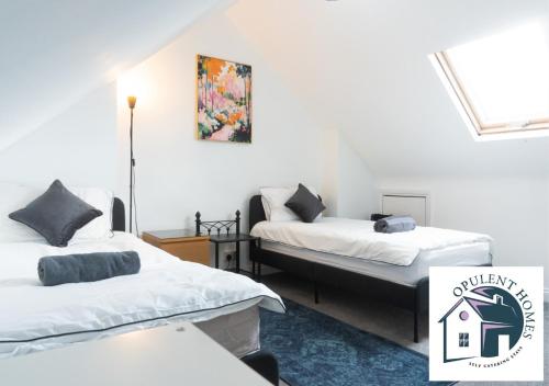 a room with two beds and a picture on the wall at Contactor Stay, Reading Town Centre 4 Bed House, Large House with 2 bath in Reading