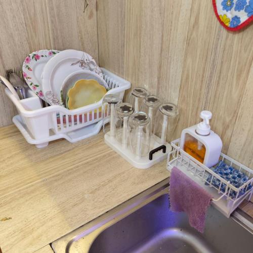 a kitchen counter with a sink and some glass containers at Jace Haven Deluxe in Binangonan