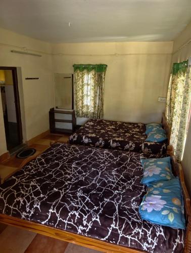 a bedroom with two beds in a room at NILORA stay KODAI in Kodaikānāl