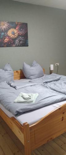 a bed with a wooden frame with a towel on it at Otto`s Ferienwohnung in Biedenkopf