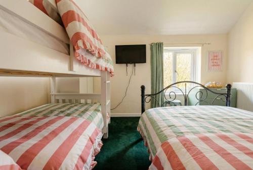 a bedroom with two twin beds and a tv at New Forest Flat Steps from Brockenhurst Station, Sleeps 4 in Brockenhurst