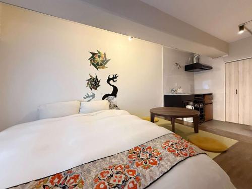 a bedroom with a large bed with two birds on the wall at Origaminn 403 by b hotel - 5 mins PeacePark in Hiroshima