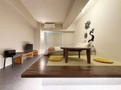 a living room with a table and a couch at Origaminn 403 by b hotel - 5 mins PeacePark in Hiroshima