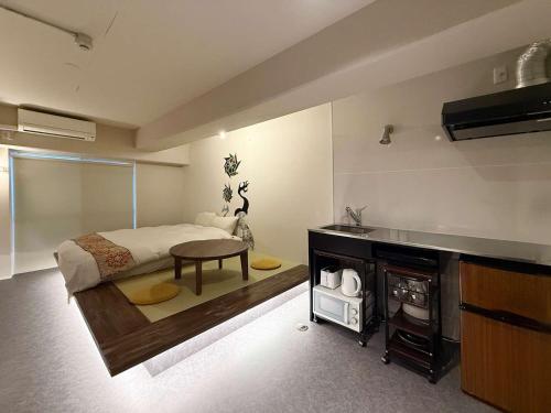 a bedroom with a bed and a table and a fireplace at Origaminn 403 by b hotel - 5 mins PeacePark in Hiroshima