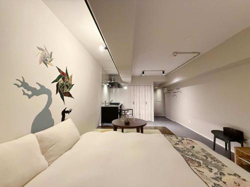 a bedroom with a large white bed and a table at Origaminn 403 by b hotel - 5 mins PeacePark in Hiroshima