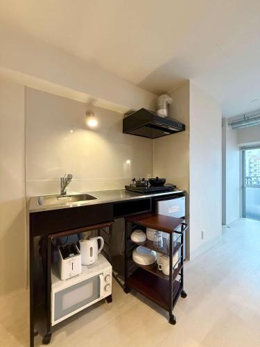 a kitchen with a sink and a counter top at Origaminn 501 by b hotel - 5 mins PeacePark in Hiroshima